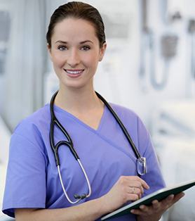 smiling nurse in blue scrub, holding a tablet